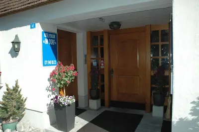 a front door of a building with potted plants at Hotel Pension Im Dorf in Zuzwil