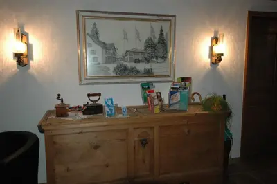 a wooden cabinet in a room with a picture on the wall at Hotel Pension Im Dorf in Zuzwil