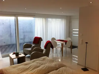 a living room with a bed and a table and chairs at Sunrise Apartment in Staad