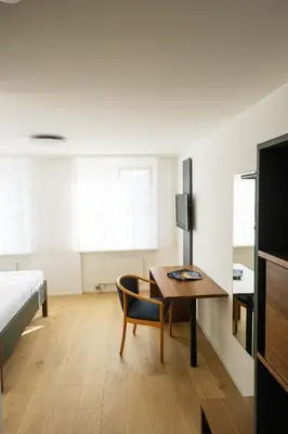 a bedroom with a desk and a bed and a table at Landgasthof Seelust in Egnach