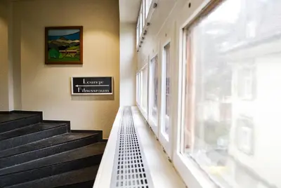 a hallway with stairs and a window in a building at Hotel Landhaus Säntis Herisau in Herisau