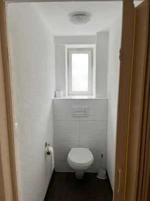 a small bathroom with a toilet and a window at Hotel Bären Amriswil in Amriswil