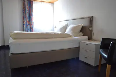 a bedroom with a bed with a window and a chair at Landgasthof Werdenberg in Werdenberg