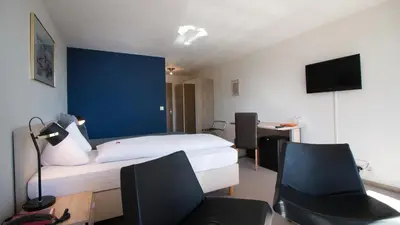 a bedroom with a bed with feet up on it at Park - Hotel Inseli in Romanshorn