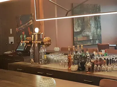 a bar with bottles and glasses on a table at Hotel Bahnhof in Uzwil