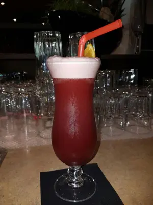 a drink in a glass with a red straw at Hotel Bahnhof in Uzwil