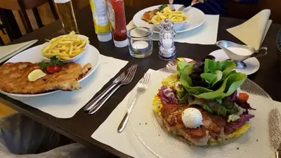 a wooden table with plates of food on it at Hotel Bahnhof in Uzwil