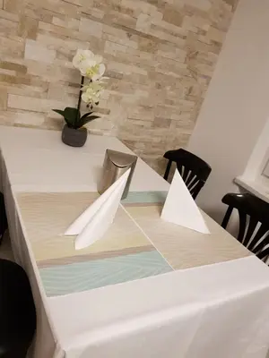 a white table with a vase of flowers on it at Hotel Elite Self-Check-in in St. Gallen