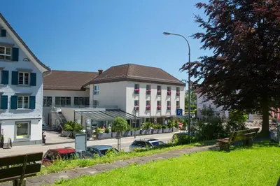 a building with cars parked in front of a street at Hotel Hecht in Rheineck