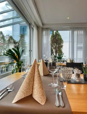 a table with wine glasses and napkins on top of it at Hotel Hecht in Rheineck
