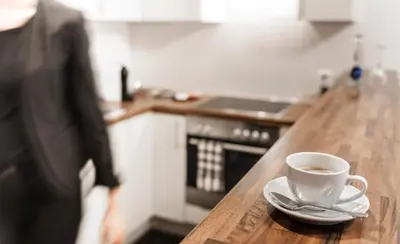 a cup of coffee on a wooden counter in a kitchen at Sky Design Motel in Kriessern