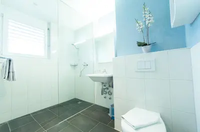 a bathroom with a toilet and a sink at Sky Design Motel in Kriessern