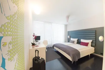 a bedroom with a bed and a desk in it at Sky Design Motel in Kriessern