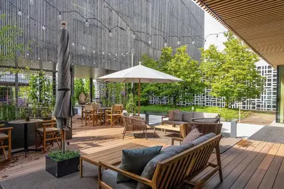 a patio with tables and chairs and an umbrella at Revier Hotel Säntispark in St. Gallen