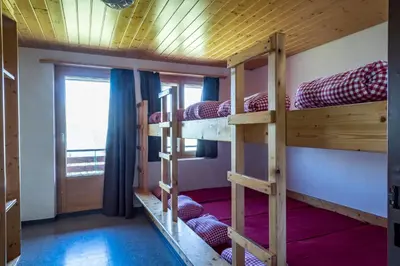 a room with three bunk beds with a window at Berghotel Sellamatt in Alt Sankt Johann