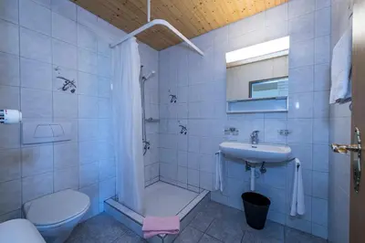 a white bathroom with a sink and a toilet at Berghotel Sellamatt in Alt Sankt Johann
