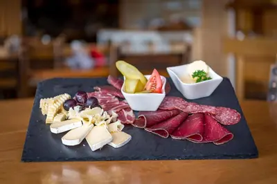 a cutting board with different types of meats and cheese at Berghotel Sellamatt in Alt Sankt Johann