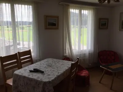 a dining room with a table and some windows at Wohlfühloase für Mensch und Hund in Uzwil