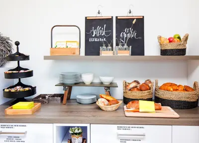 a kitchen with shelves with bread and baskets of food at Hotel Restaurant Rhy in Oberriet