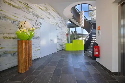 a hallway with a staircase and a vase of flowers at Hotel Restaurant Rhy in Oberriet
