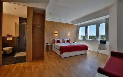 a hotel room with a bed and a bathroom at Hotel Restaurant Rhy in Oberriet