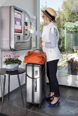 a woman is putting money in a pay phone at Hotel Restaurant Rhy in Oberriet