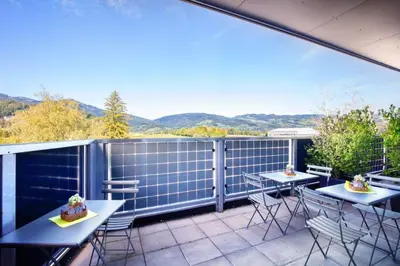 a patio with two tables and chairs on a balcony at Hotel Restaurant Rhy in Oberriet