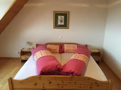 a bedroom with a bed with two pink pillows at Landgasthof Winzelnberg in Egnach