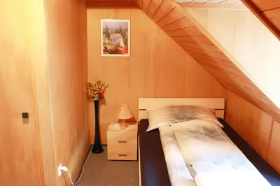a small bedroom with a bed and a staircase at Restaurant Blume in St. Gallen