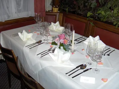 a table with a white table cloth and flowers on it at Restaurant Blume in St. Gallen