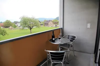 a balcony with a table and chairs and a window at wohnMOTEL - Hinterforst in Altstätten