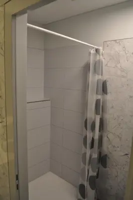 a shower with a black and white shower curtain at Loft AR in Bühler