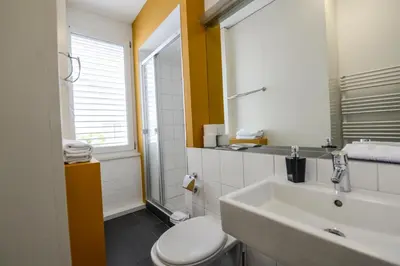 a bathroom with a sink and a toilet and a window at Berger Zentrum in Berg
