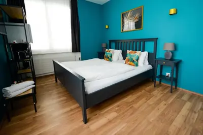 a bedroom with a bed with blue walls and wooden floors at Berger Zentrum in Berg