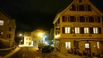 a street at night with a building and a car at Pizzeria-Pension Gambrinus in Walzenhausen