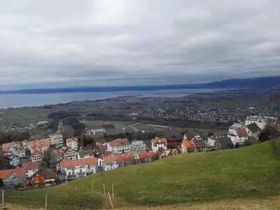 a town on top of a hill with a body of water at Pizzeria-Pension Gambrinus in Walzenhausen