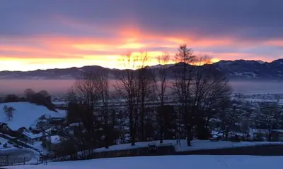 a sunset over a town in the snow at Pizzeria-Pension Gambrinus in Walzenhausen