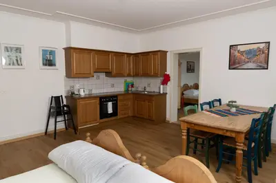 a living room with a table and a kitchen at Gasthof Zur Traube in Roggwil