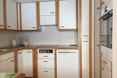 a kitchen with white appliances and wooden cabinets at Sitter-Panorama in Bischofszell