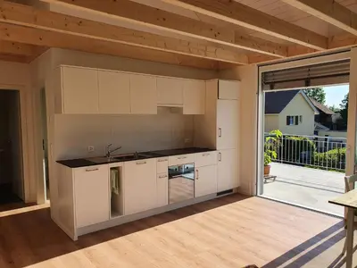 an outdoor kitchen with white cabinets and a large window at Sitter-Panorama in Bischofszell