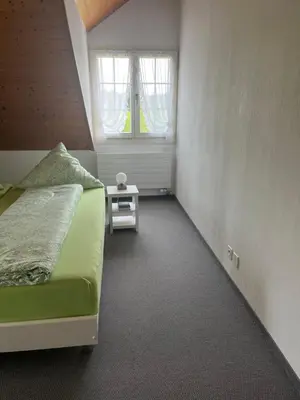 a bedroom with a bed and a small table at Sitter-Panorama in Bischofszell
