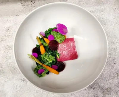 a plate of food with vegetables on a table at Businesshotel Forum Widnau in Widnau