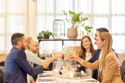 a group of people sitting around a table with wine glasses at Businesshotel Forum Widnau in Widnau