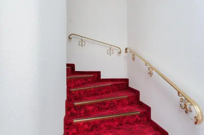 a red carpeted staircase with a red carpeted stair case at Hotel Mozart in Rorschach