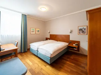 a hotel room with a bed and a desk at Hotel Hecht in Appenzell