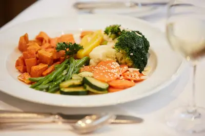 a plate of food with vegetables on a table at Hotel & Spezialitätenrestaurant zur Linde in Teufen