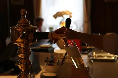 a person is pouring wine into a glass at Hotel & Spezialitätenrestaurant zur Linde in Teufen
