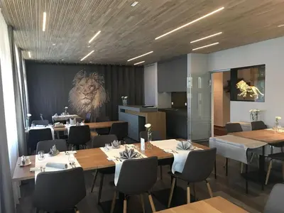 a dining room with tables and a lion on the wall at Landgasthof Lowen in Sulgen