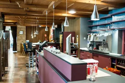 a kitchen with a counter and a bar with chairs at Landgasthof Lowen in Sulgen