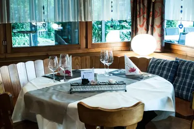 a table with a white table cloth and wine glasses at Landgasthof Lowen in Sulgen